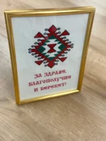 Пано с шевица Канатица в златна рамка, поставено на маса
